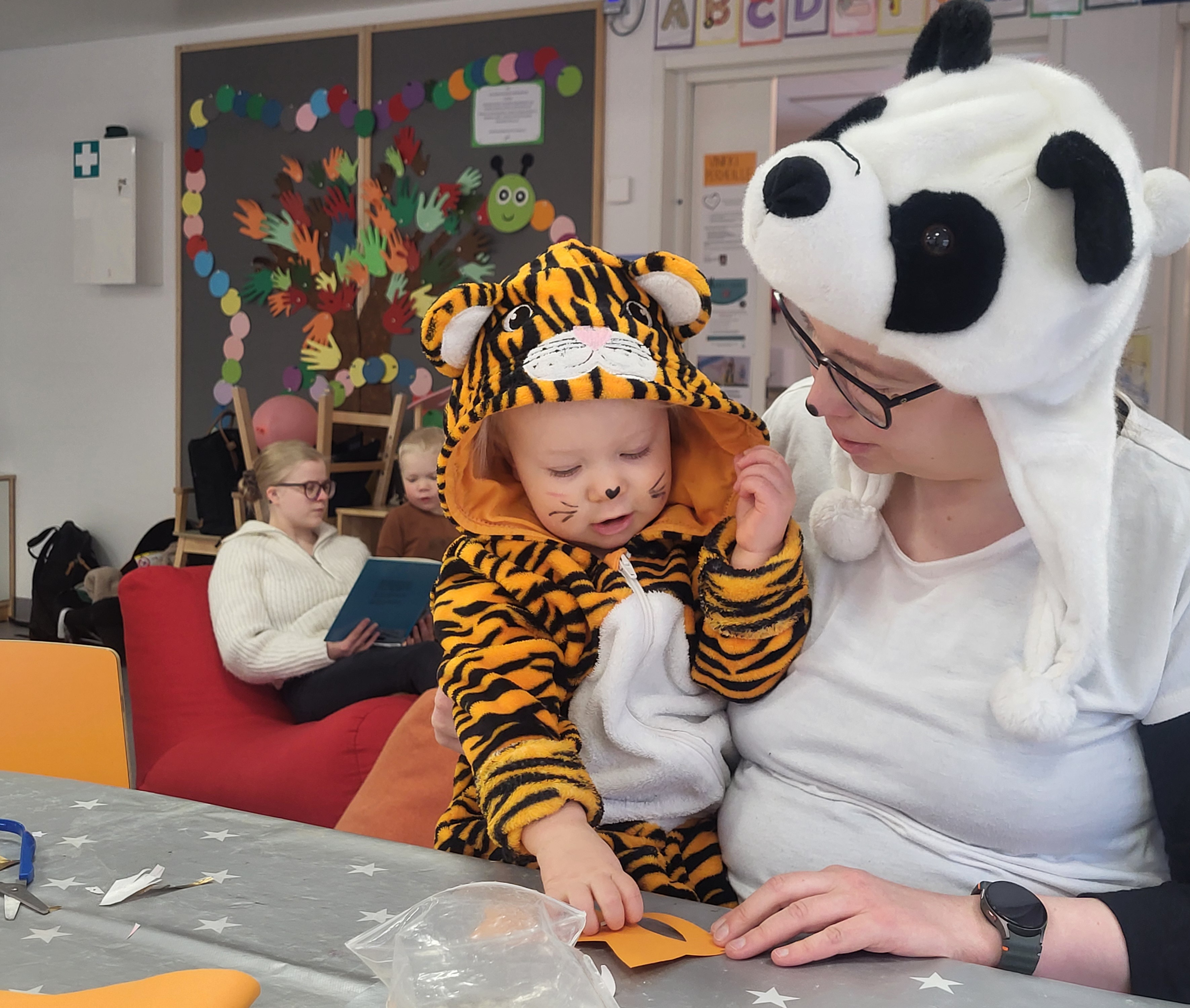 Kuva perhekerhon kävijöistä naamiaisasuissaan.