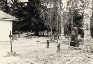 Hautakiviä ja risti vanhalla hautausmaalla