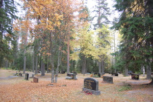 Hautausmaa syksyllä. Ruskalehdet peittävät maata.
